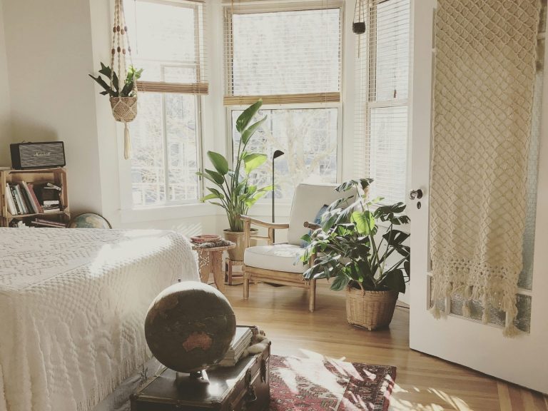 Helle, gemütliche Wohnräume mit Pflanzen und einem Sessel in einem sonnigen Fenster.